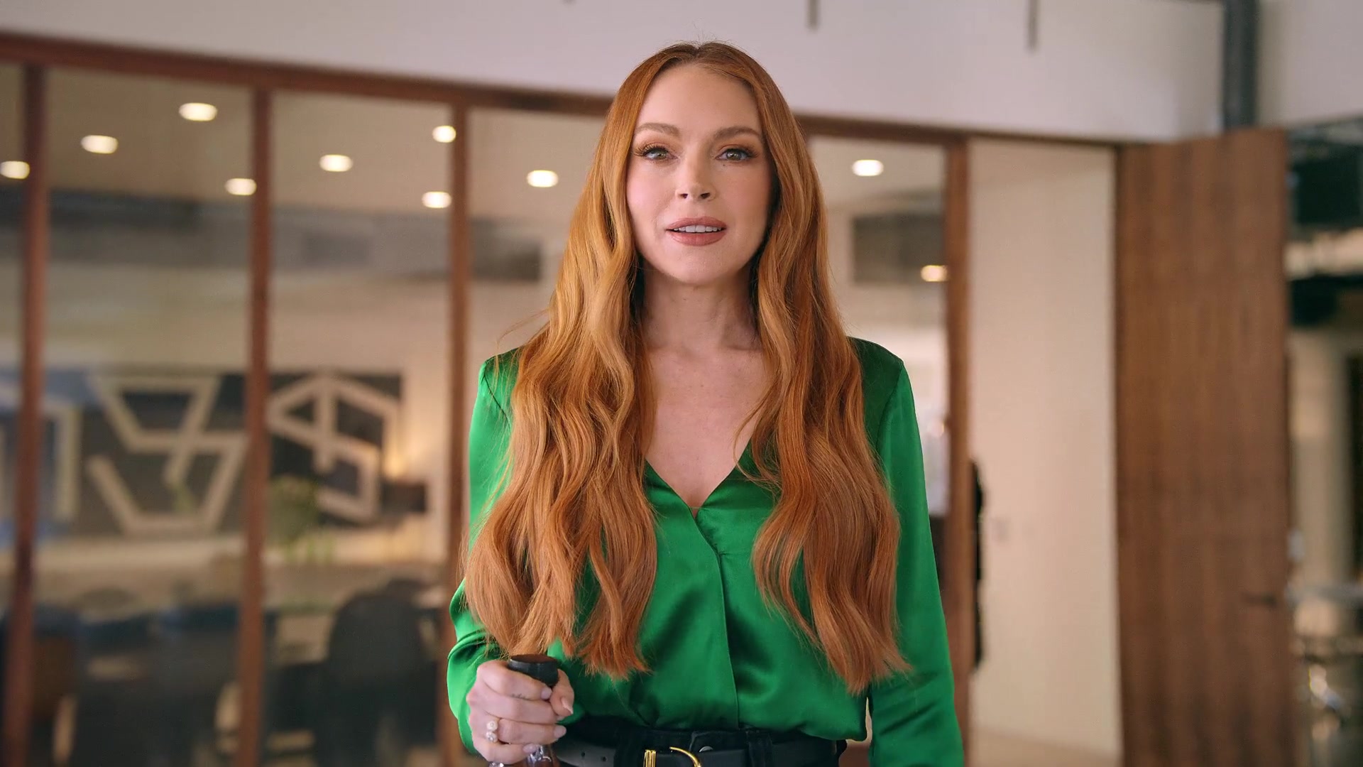 Lindsay Lohan addresses the camera in an office, holding a Pure Leaf bottle in Kelsey Taylor’s Tea Break film