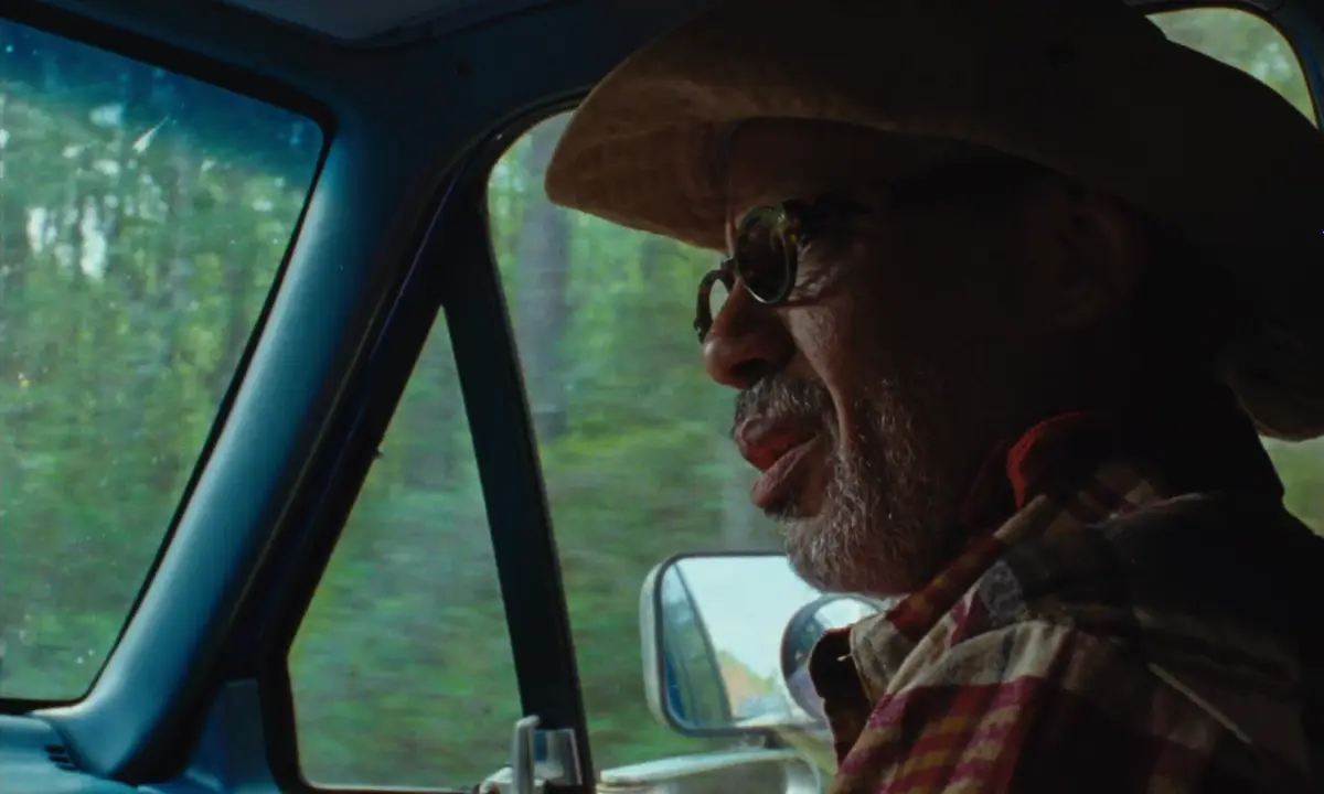 A man in a cowboy hat riding in a pickup in Common Ground, directed by Nate Townsend for The Carter Center