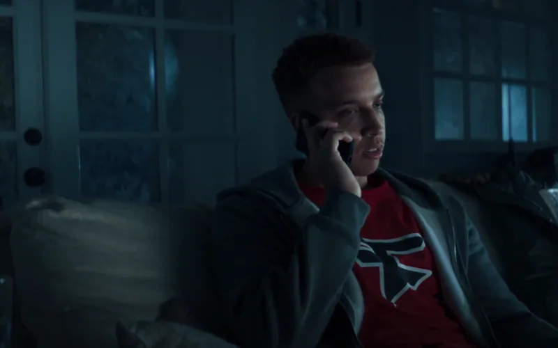 A man listens on his phone in a blue-lit room in Call of Duty The Haunting.