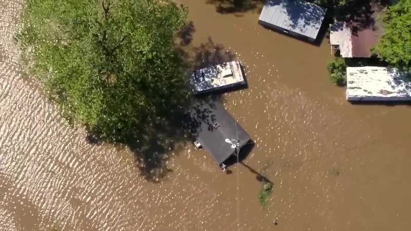 An aerial view of houses surrounded by flood water.