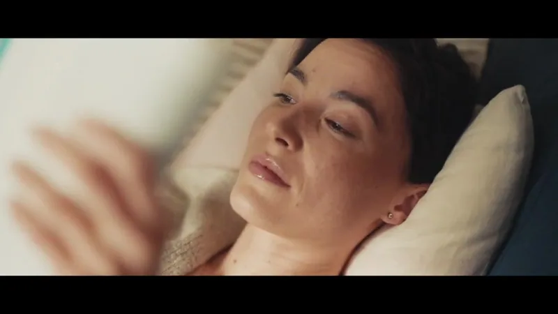 A woman reclines with a book in soft sunlight.