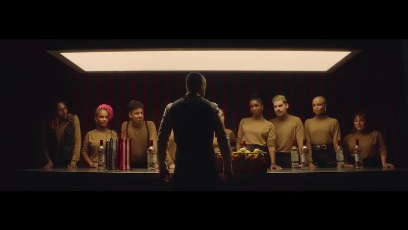 An ensemble stands around a bar beneath a bright ceiling panel.