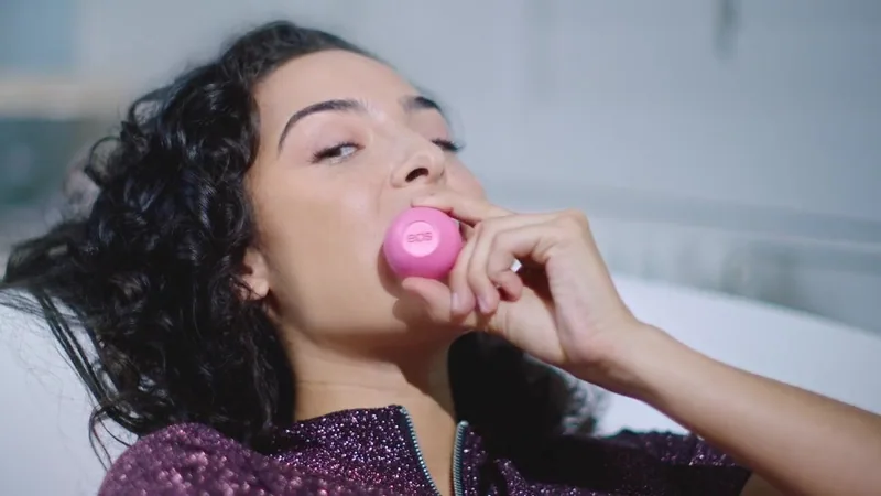 Woman holding a pink EOS lip balm sphere