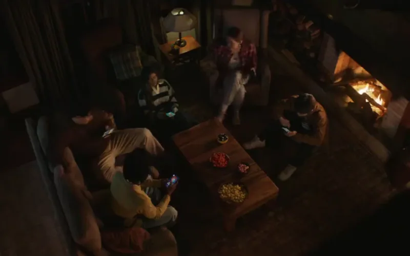 An overhead view of friends around a coffee table and fireplace in Clash Royale Lose If You Dare.