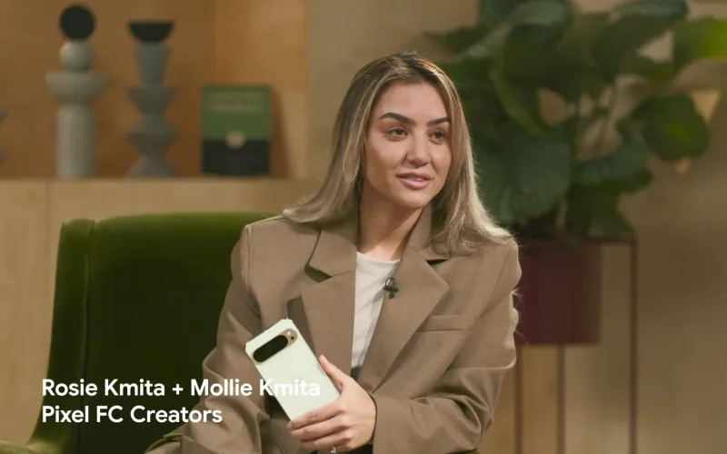A Pixel FC creator holds a Google Pixel phone during a conversation with Rosie and Mollie Kmita.