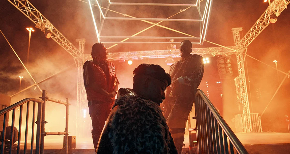 Performers silhouetted against a glowing orange stage in KFC’s Feed Your Original film